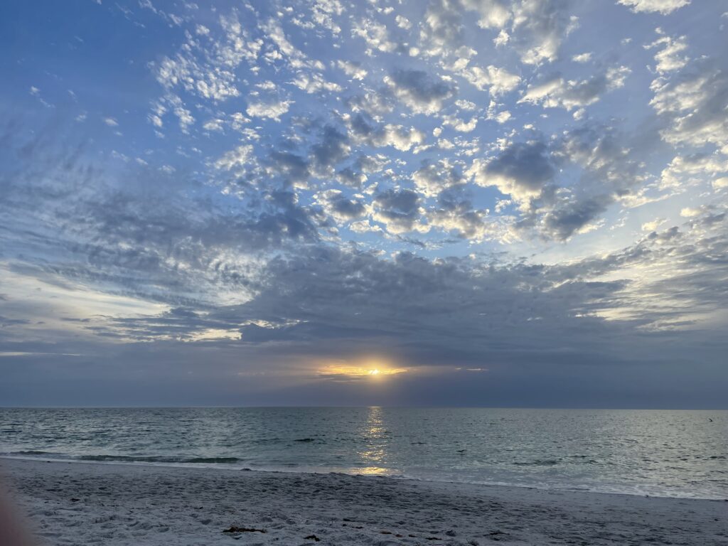 Tranquil view of the horizon where the calm sea meets the sky at the beach, reflecting the serene beauty of nature and the peaceful expanse of water.